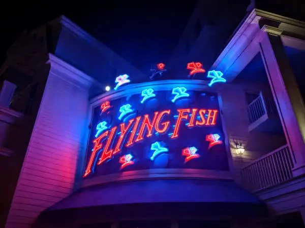 Flying Fish Disney sign lit up at night