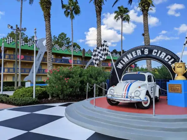 Herbie Love Bug statue in winners circle with All Star Movies resort rooms in background